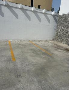 un estacionamiento vacío junto a una pared blanca en Departamento Madero, en Ciudad Madero