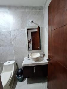 y baño con lavabo, aseo y espejo. en Departamento Madero, en Ciudad Madero
