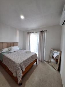 1 dormitorio con cama, espejo y ventana en Departamento Madero, en Ciudad Madero