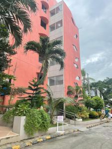 a red building with palm trees in front of it at The Penthouse Suite in Pusok
