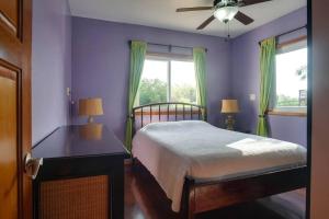 Schlafzimmer mit einem Bett, einem Tisch und einem Fenster in der Unterkunft Bahia Vista - Spectacular Views - 4 Bedrooms in Placencia Village