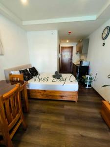 een slaapkamer met een bed in een kamer met een keuken bij Megatower 4 6F 24 Pines Stay Condotel Near SM & Burnham in Baguio