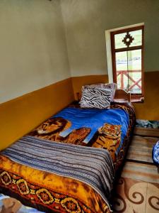 - une chambre avec un lit doté d'une couette bleue et d'une fenêtre dans l'établissement HOMESTAY KINSA COCHA, à Pisac
