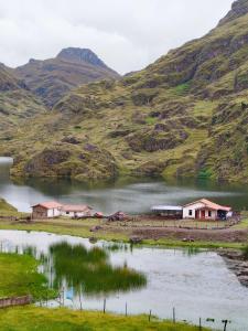 un groupe de maisons sur un lac dans une montagne dans l'établissement HOMESTAY KINSA COCHA, à Pisac