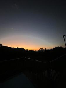 una puesta de sol en el cielo con una valla en primer plano en Hotel Campestre Las Marias- El Colegio, en El Colegio