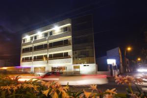 a building at night with traffic in front of it at Hotel Joshed Imperial in Latacunga