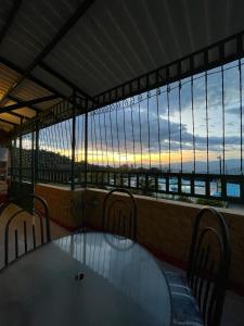 a table and chairs on a balcony with a view of the ocean at Hotel Campestre Las Marias- El Colegio in El Colegio