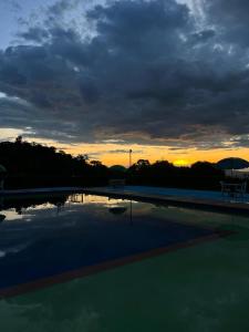 puesta de sol sobre una piscina con puesta de sol en Hotel Campestre Las Marias- El Colegio, en El Colegio