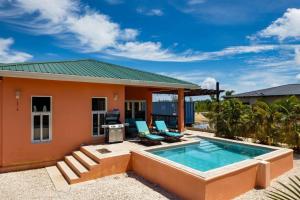una casa con piscina frente a ella en Casa Valencia - Modern Pool Family Luxury Sleeps 8, en Placencia Village