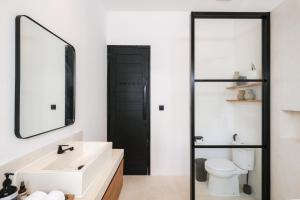 a bathroom with a white sink and a mirror at Villa Neptune Uluwatu in Uluwatu