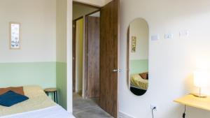 1 dormitorio con cama y puerta con espejo en Casa Selva en Medellín