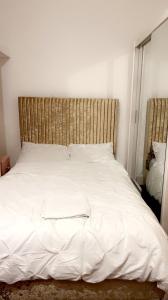 uma cama branca com uma cabeceira em madeira num quarto em 68 Halsbury Road em Liverpool