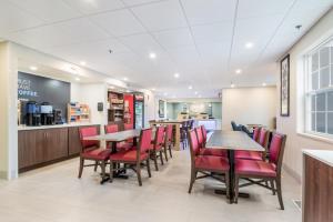 a restaurant with red chairs and tables and a counter at Holiday Inn Express - Plymouth, an IHG Hotel in Plymouth