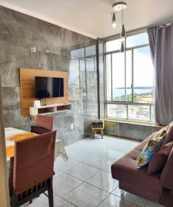 a living room with a couch and a tv at Apto com vista para Baía do Guajará in Belém