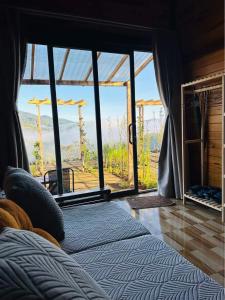 a bedroom with a bed with a view of a mountain at TopView Măng Đen in Kon Von Kla