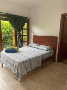 um quarto com uma cama grande e uma janela em Finca Hotel Casa Lupe En Santa Elena em El Cerrito