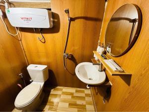 a bathroom with a toilet and a sink and a mirror at TopView Măng Đen in Kon Von Kla