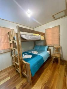 a bedroom with two bunk beds and a chair at Cashew Tree Cabana - Small Cosy, Close to the Beach. in Placencia