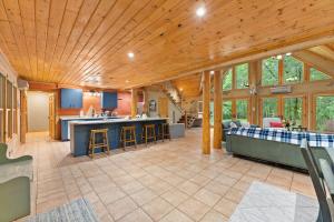 Private Cabin at Lake Hartwell في Townville: مطبخ كبير وغرفة معيشة بسقف خشبي