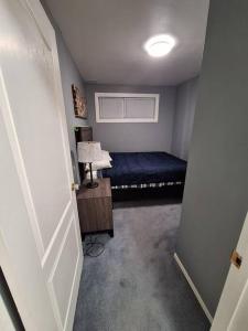 ein kleines Zimmer mit einem Bett und einer Lampe in der Unterkunft 1-Bedroom Basement Suite in Yellowknife