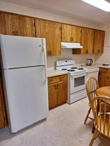 eine Küche mit einem weißen Kühlschrank und einem Tisch in der Unterkunft 1-Bedroom Basement Suite in Yellowknife
