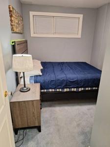 ein Schlafzimmer mit einem Bett und einem Tisch mit einer Lampe in der Unterkunft 1-Bedroom Basement Suite in Yellowknife + 9 Fotos