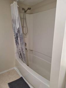 ein Badezimmer mit Dusche und weißer Badewanne in der Unterkunft 1-Bedroom Basement Suite in Yellowknife