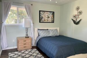 Un dormitorio con una cama azul y una ventana en Delightful family-friendly home in the heart of WA en Olympia