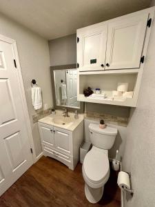 y baño con aseo blanco y lavamanos. en Delightful family-friendly home in the heart of WA en Olympia