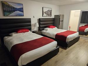 um quarto com 2 camas com lençóis vermelhos e brancos em Mountain View Hope Motel em Hope