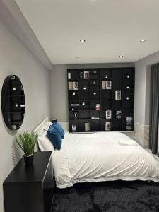 een slaapkamer met een groot bed met een zwart hoofdeinde bij Stylish entire 2bed apartment in Londen