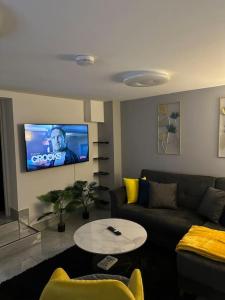 ein Wohnzimmer mit einem Sofa und einem TV in der Unterkunft Stylish entire 2bed apartment in London