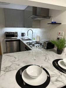 a kitchen with a table with a plate and a wine glass at Stylish entire 2bed apartment in London