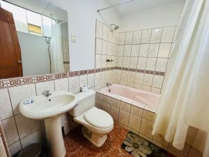 a bathroom with a sink and a toilet and a tub at Villa Salluzzi Apart Hotel in Tacna +66 photos