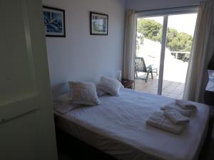 - une chambre avec un lit et des serviettes dans l'établissement "La Terrasse de la mer 8" -Climatisation-Wifi-BBQ -Piscine-Parking, à Begur