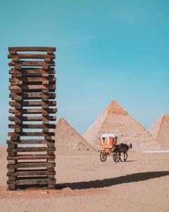 a horse drawn cart in front of the pyramids at Pyra Hospitality West Pyramids Cairo in Cairo