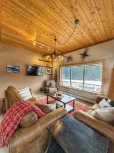 a living room with two couches and a table at Bear Lake Lodgings B&B in Seward