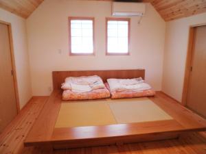 a room with two beds on the floor at 風車村3-G-1B号棟 in Aiba