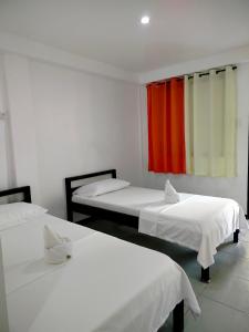 a room with three beds and a red curtain at Lang2 place in Coron