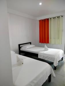 2 Betten in einem Zimmer mit rotem Fenster in der Unterkunft Lang2 place in Coron