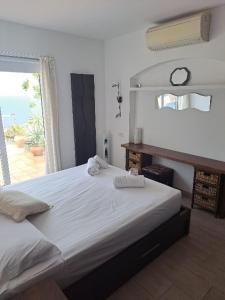 - une chambre avec un grand lit blanc et une fenêtre dans l'établissement "La Terrasse de la mer 8" -Climatisation-Wifi-BBQ -Piscine-Parking, à Begur
