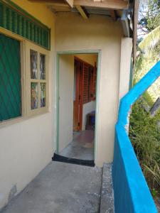 een ingang naar een huis met een blauw hek bij Lady Gordons Homestay in Kandy
