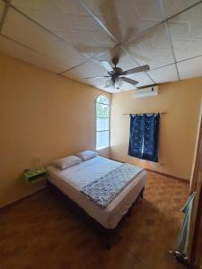1 dormitorio con 1 cama y ventilador de techo en Habitacion cerca del lago, en Flores