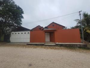 a orange house with a white garage at Habitacion cerca del lago in Flores