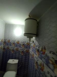 een badkamer met een toilet en een lampje aan de muur bij Bhagwan sri Ramakrishna sewa tarst in Ayodhya