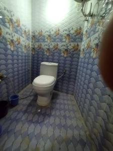 een badkamer met een toilet en een blauwe betegelde muur bij Bhagwan sri Ramakrishna sewa tarst in Ayodhya