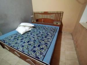 een slaapkamer met een bed met een blauw gedessineerd matras bij Bhagwan sri Ramakrishna sewa tarst in Ayodhya
