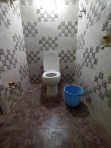 een badkamer met een toilet en een blauwe emmer bij Bhagwan sri Ramakrishna sewa tarst in Ayodhya