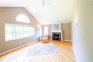 una sala de estar vacía con silla y chimenea en Charming Affordable Accommodation 20 min to Toronto P3 en Pickering