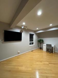 una camera vuota con TV a schermo piatto a parete di Charming Affordable Accommodation 20 min to Toronto P3 a Pickering